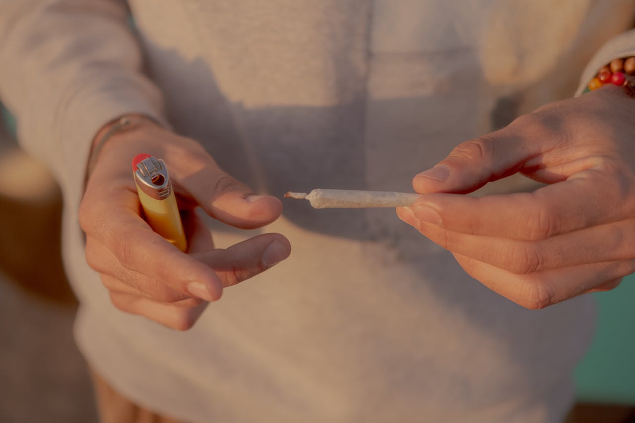 Person Holding Cigarette Stick With Lighter